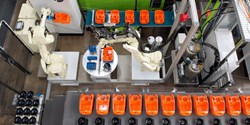 Der 6-Achs-Roboter legt Staubsauger- und Motortopfgehäuse für den Dosierauftrag in einem Schritt auf den Rundtakttisch-Teileaufnahmen ab (Bild: Henkel)